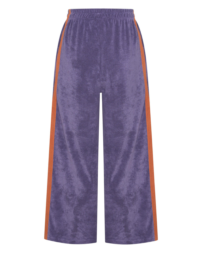 Purple velvet pants with orange side stripes on a white background