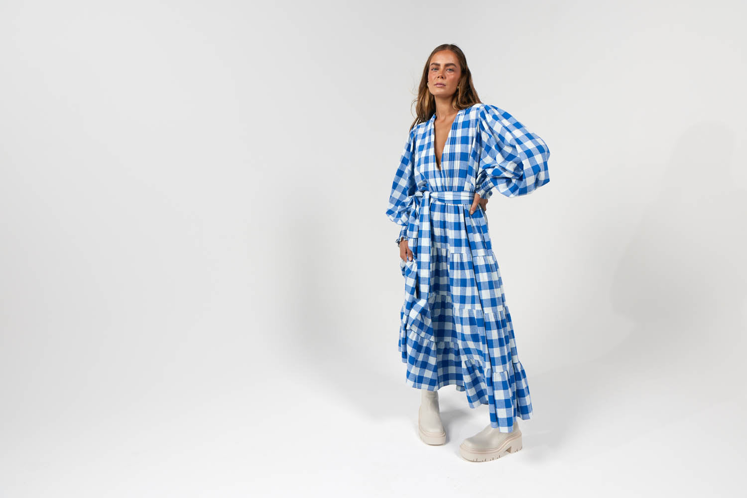 Model wearing white and blue gingham printed maxi dress with puff sleeves. Perfect for winter fashion dressing ideas