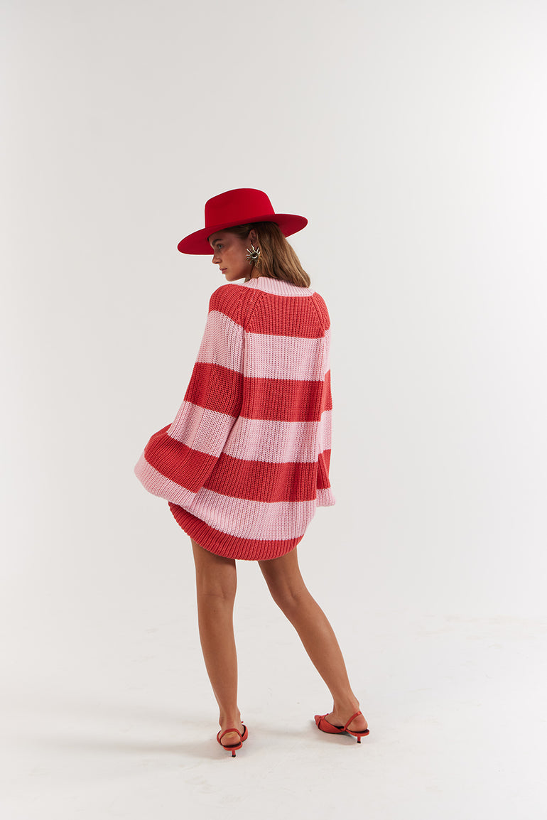 Woman wearing a red and white striped dress with a matching hat