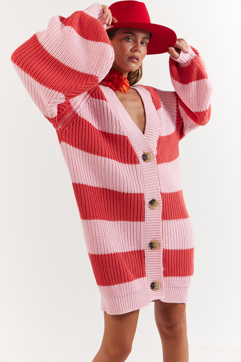Person wearing a red and white striped cardigan with a red hat