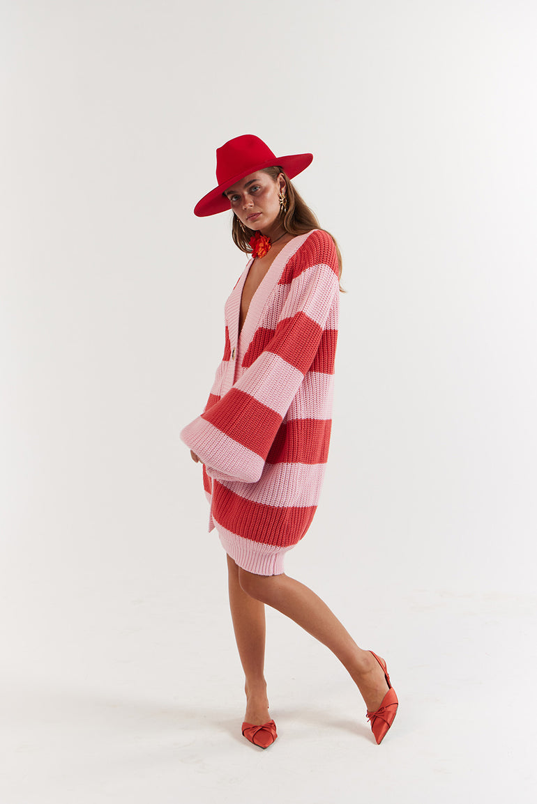 Woman wearing a red and white striped knitted dress with a matching red hat