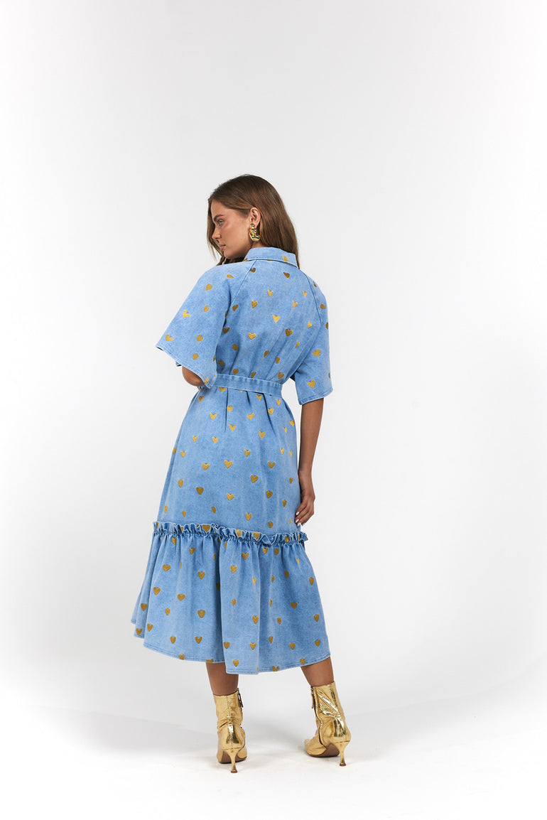 Woman wearing a blue denim dress with gold hearts