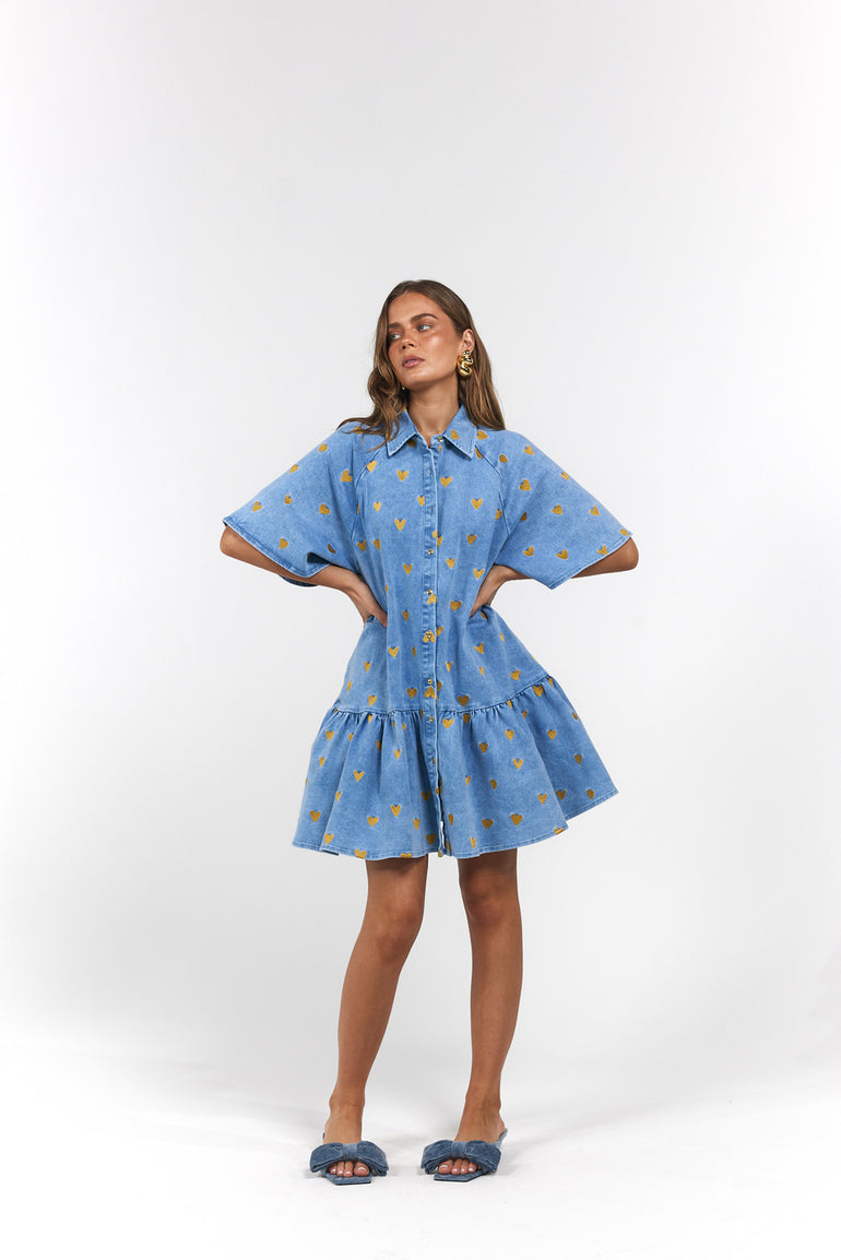 Woman wearing a blue Denim Hearts dress with gold hearts
