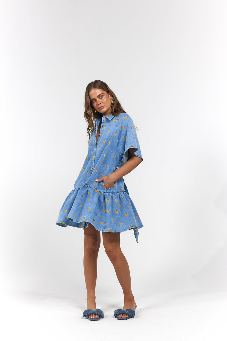Woman wearing a blue dress with gold hearts
