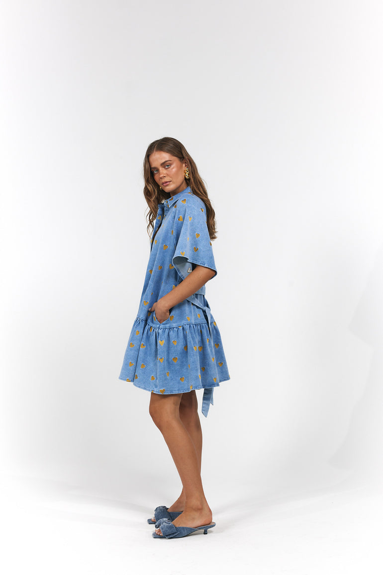 Woman wearing a blue dress with gold hearts