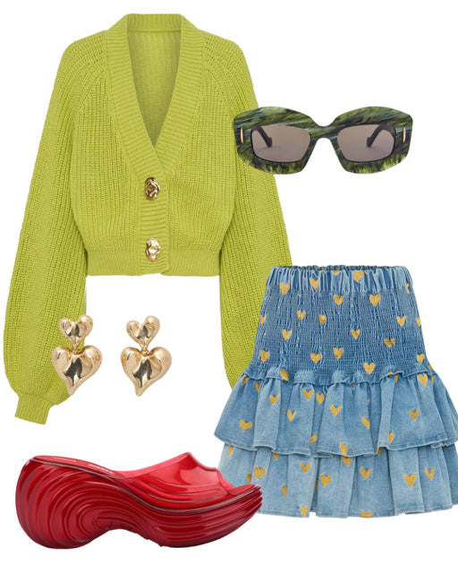 Green cardigan, blue denim skirt with yellow hearts, red shoes, gold heart earrings, and green sunglasses on a white background.