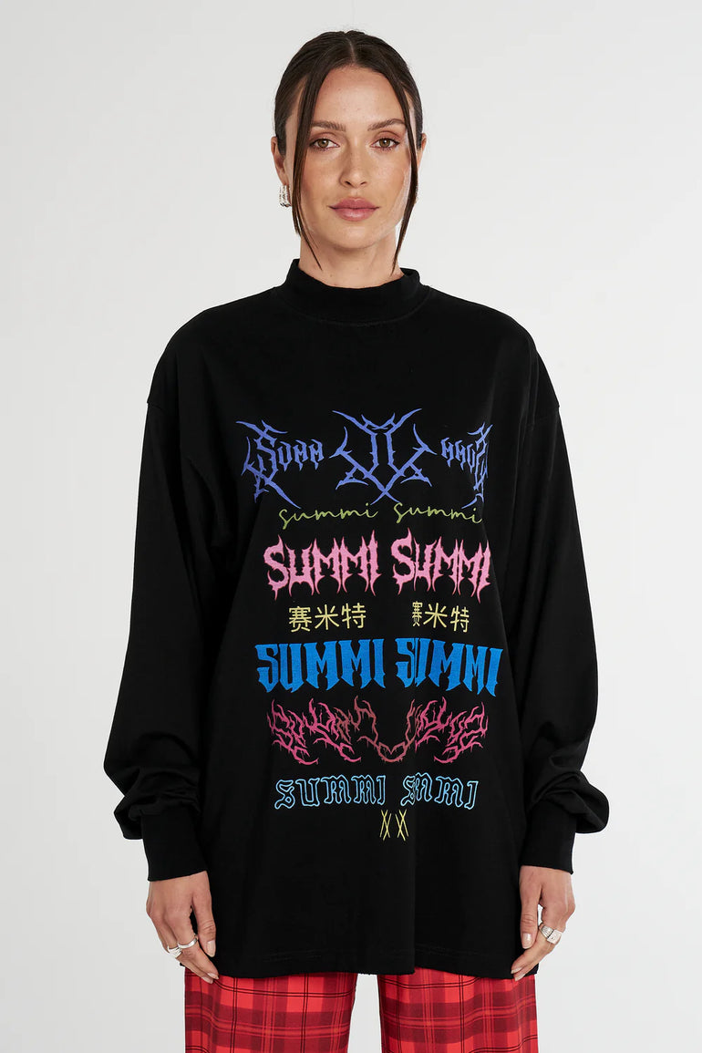 Person wearing a black oversized Summi Summi sweater with colorful text and graphics on a white background