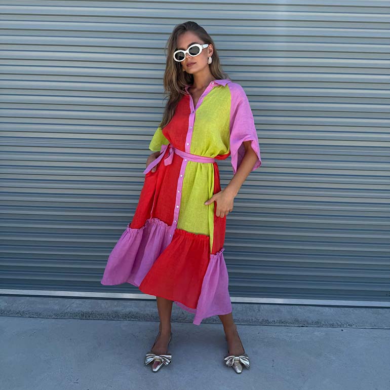 Woman wearing a colourful candy Stripe dress with red, green, and pink hues.