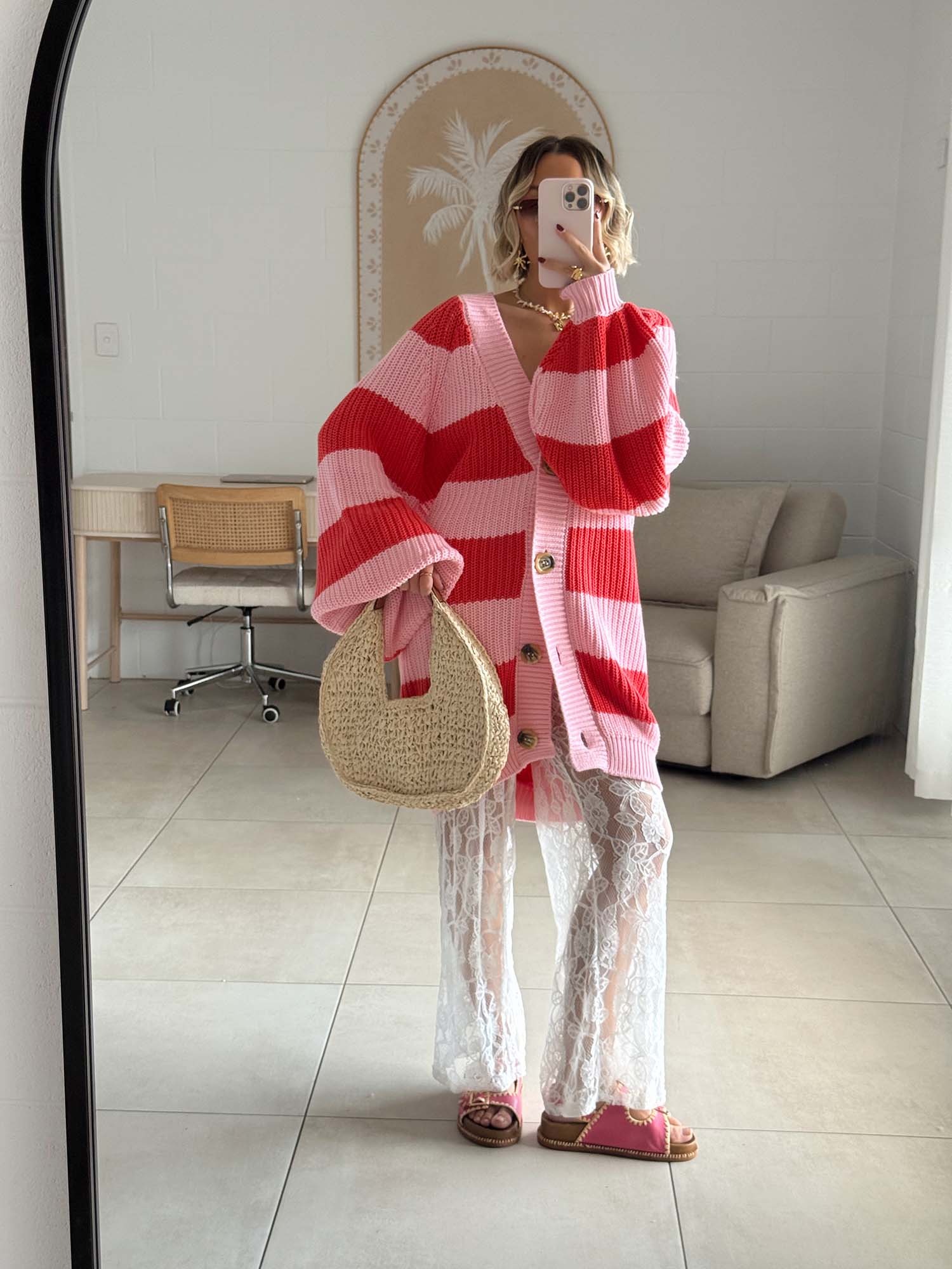 Lady wearing a red and pink striped La Bohème Lifestyle Elsie Knit cardigan in a room with a mirror.