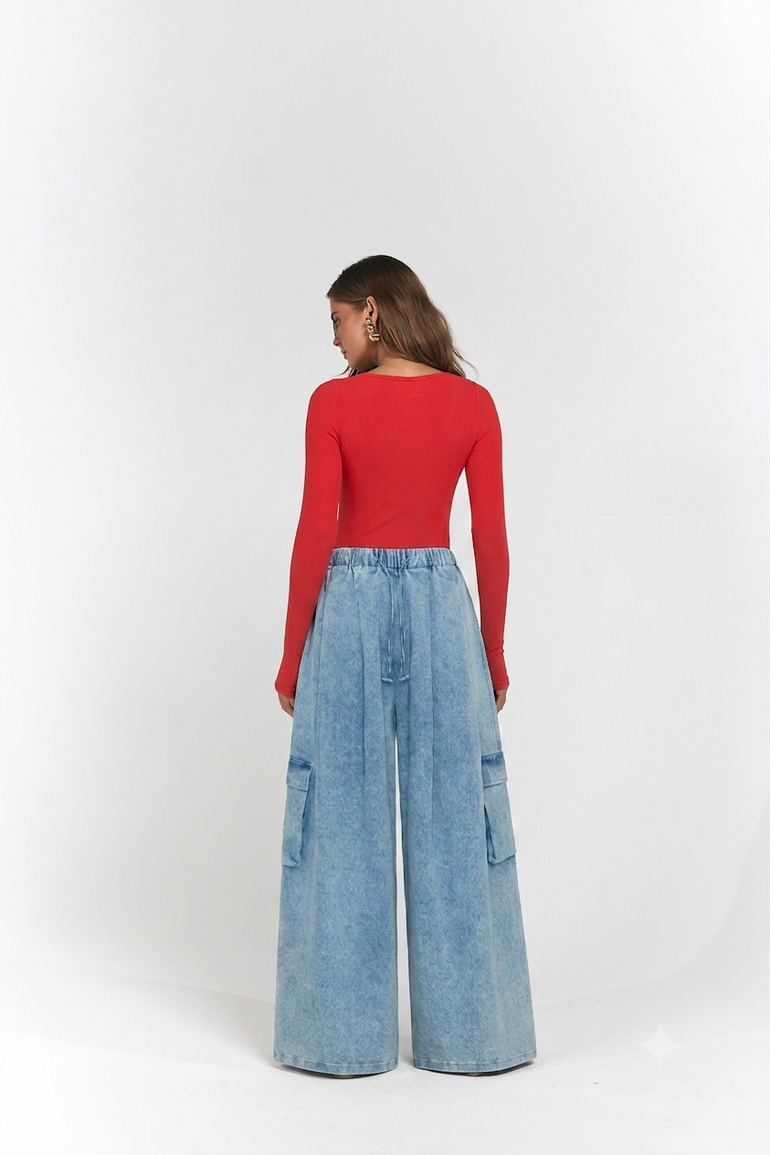 A woman is shown from the back wearing a bright red long-sleeve top and light blue wide-leg denim cargo pants.