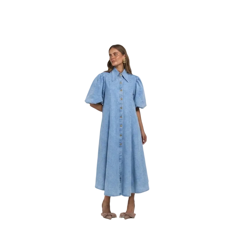 A woman modelling a light blue denim midi dress with puff sleeves, a button-down front, and a relaxed A-line silhouette.