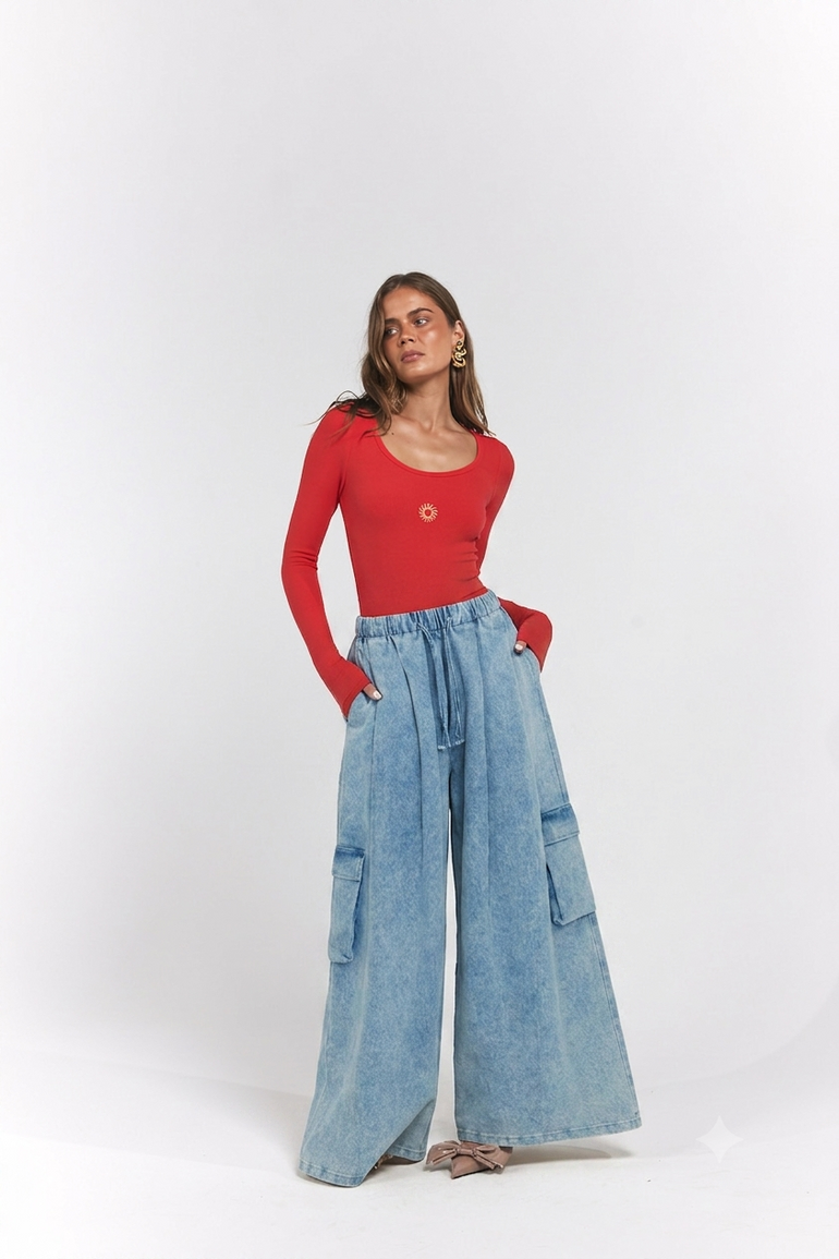 A woman modeling a red long-sleeve scoop-neck top paired with high-waisted, wide-leg light blue denim cargo pants.
