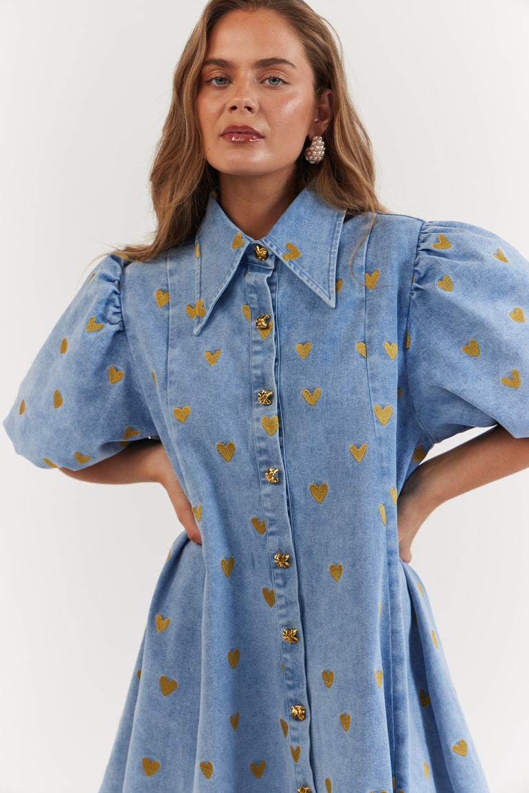 Woman wearing a blue denim dress with gold heart pattern - Denim Hearts by La Bohème