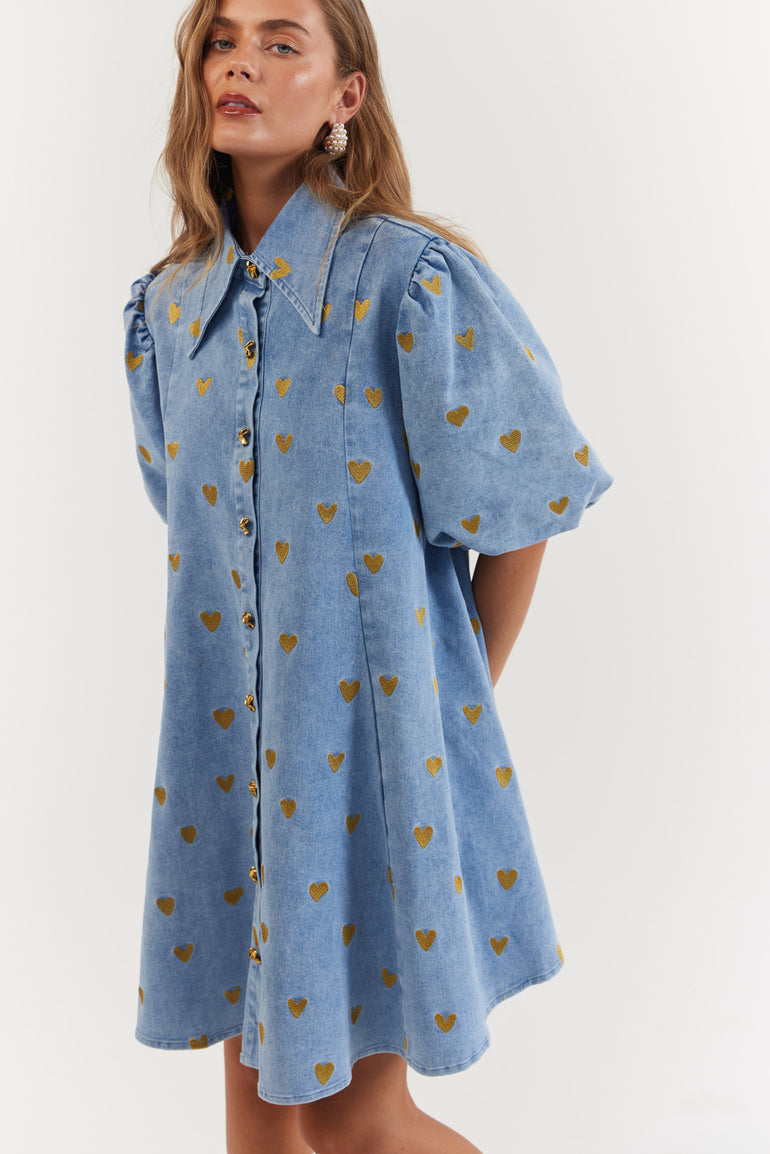 Woman wearing a blue dress with gold heart pattern