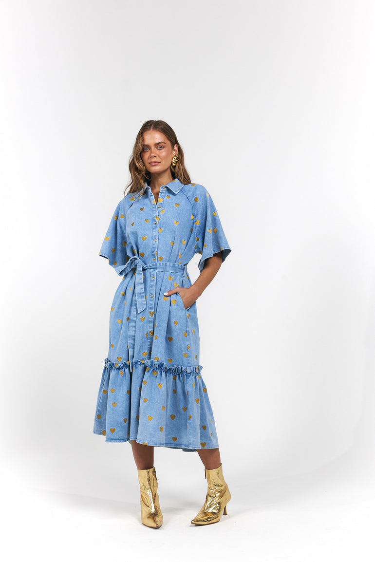 Woman wearing a blue denim dress with gold hearts