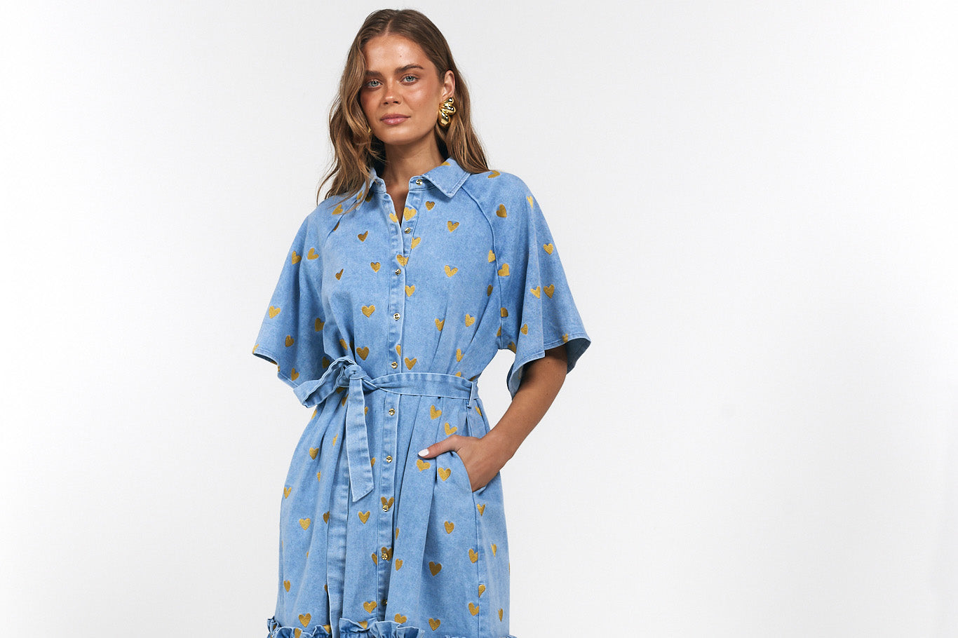 Woman wearing a blue denim dress with gold hearts